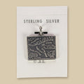 Vintage Maisel's Sterling Silver Colorado Map Charm, New Old Stock, shown on a sand background