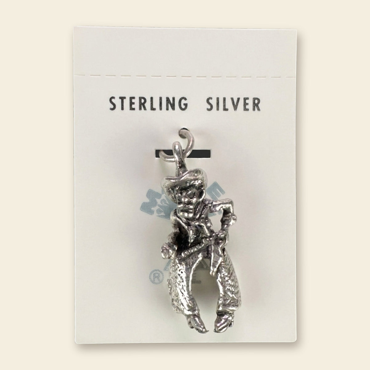 Vintage Maisel's Sterling Silver Cowboy Charm, New Old Stock, shown on an ivory background