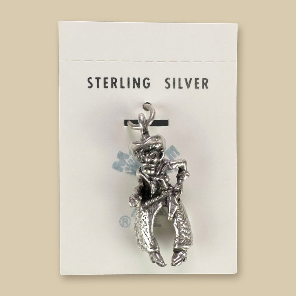 Vintage Maisel's Sterling Silver Cowboy Charm, New Old Stock, shown on a sand background