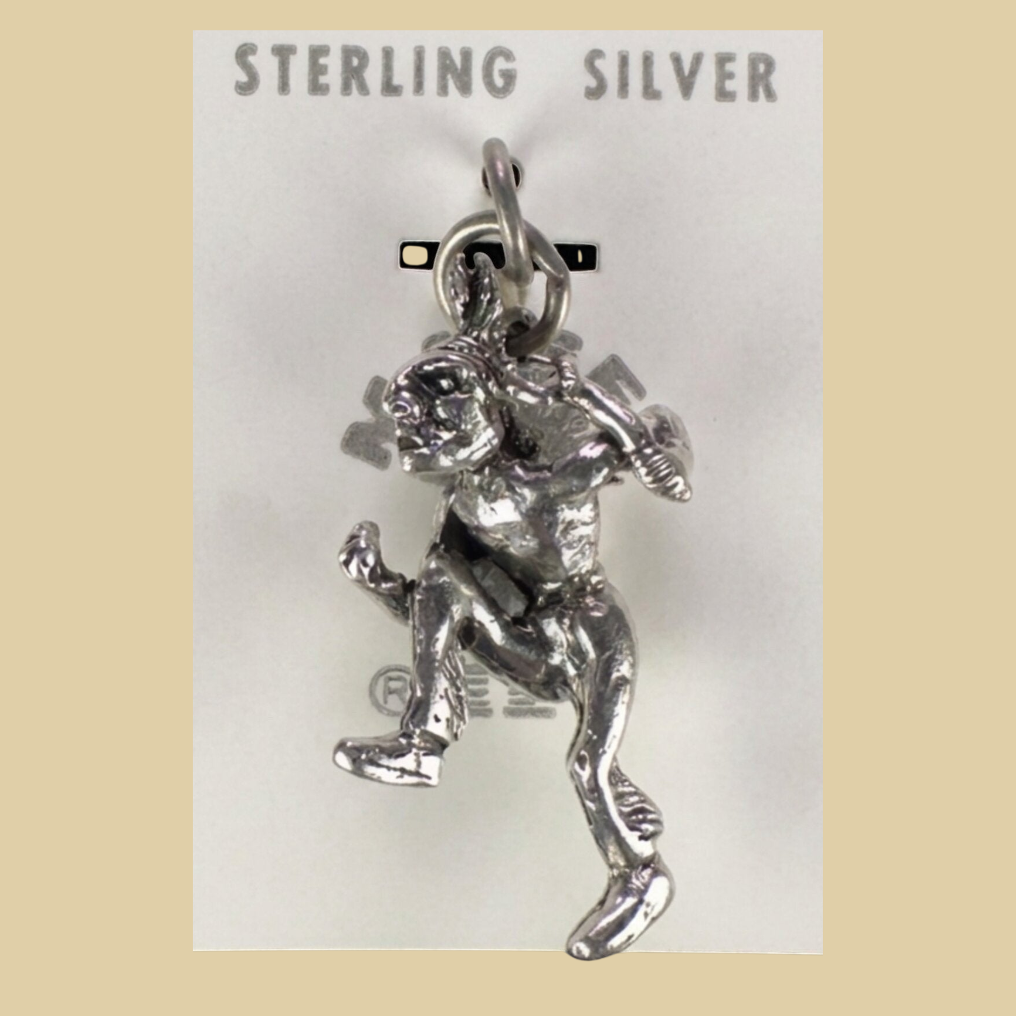 Vintage Maisel's Sterling Silver Dancer Charm, New Old Stock, shown on a desert plaster background