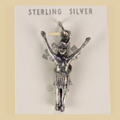 Vintage Maisel's Sterling Silver Figure with Arms Raised Charm, New Old Stock, shown on a desert plaster background