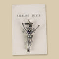 Vintage Maisel's Sterling Silver Figure with Arms Raised Charm, New Old Stock, shown on a sand background
