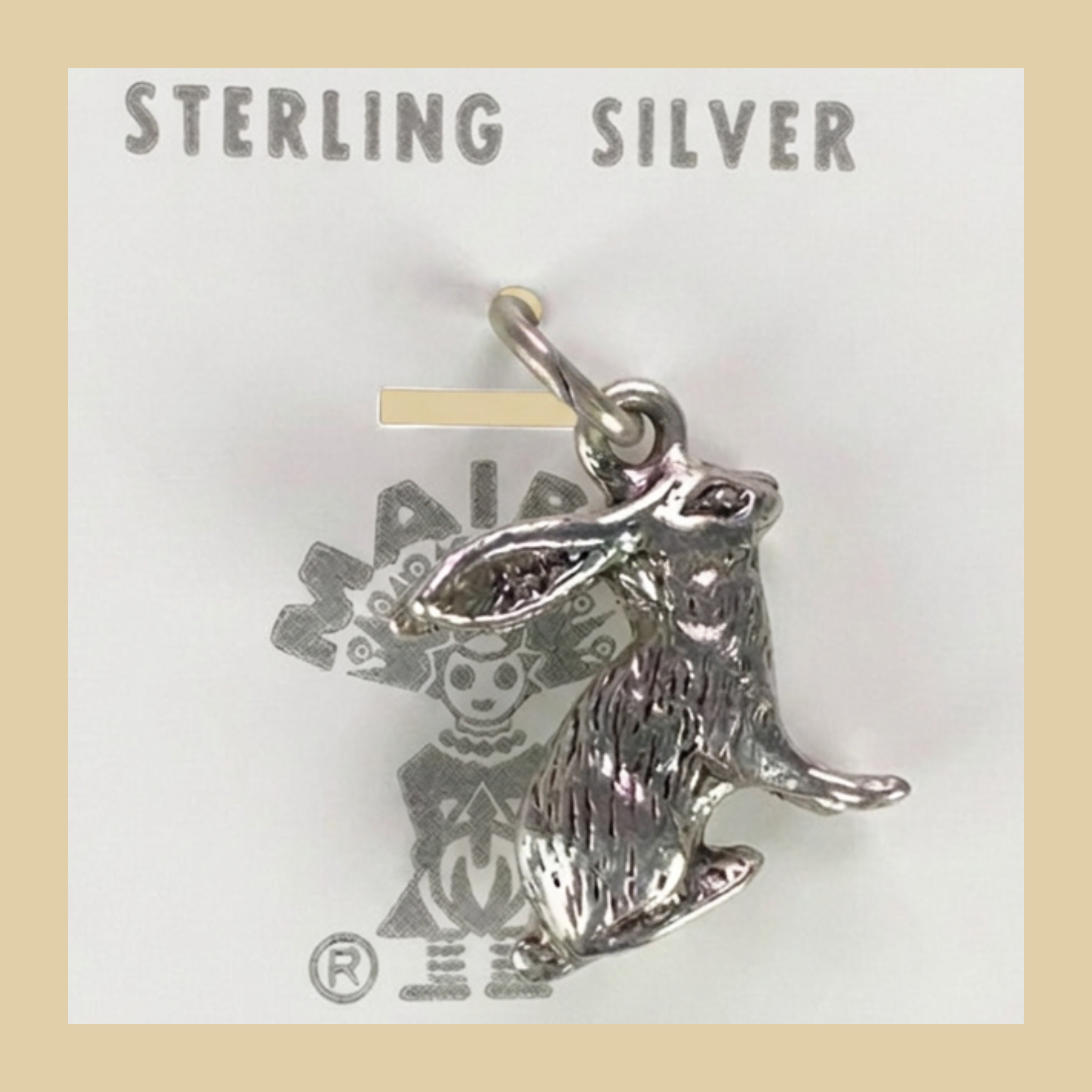 Vintage Maisel's Sterling Silver Jackrabbit Charm, New Old Stock, shown on a desert plaster background
