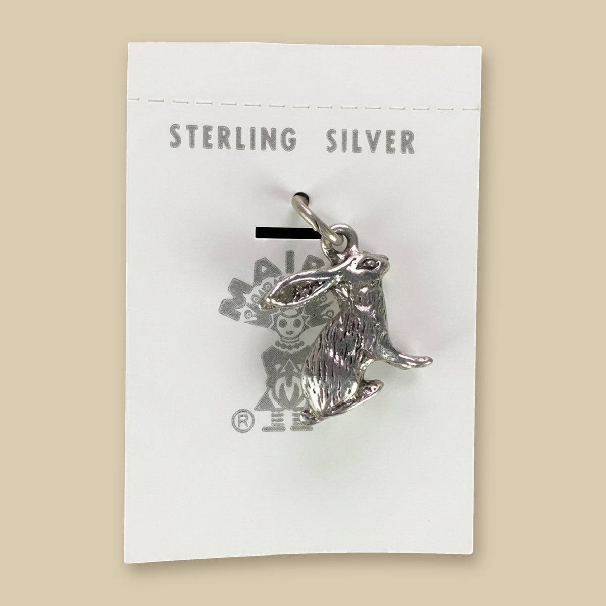 Vintage Maisel's Sterling Silver Jackrabbit Charm, New Old Stock, shown on a sand background