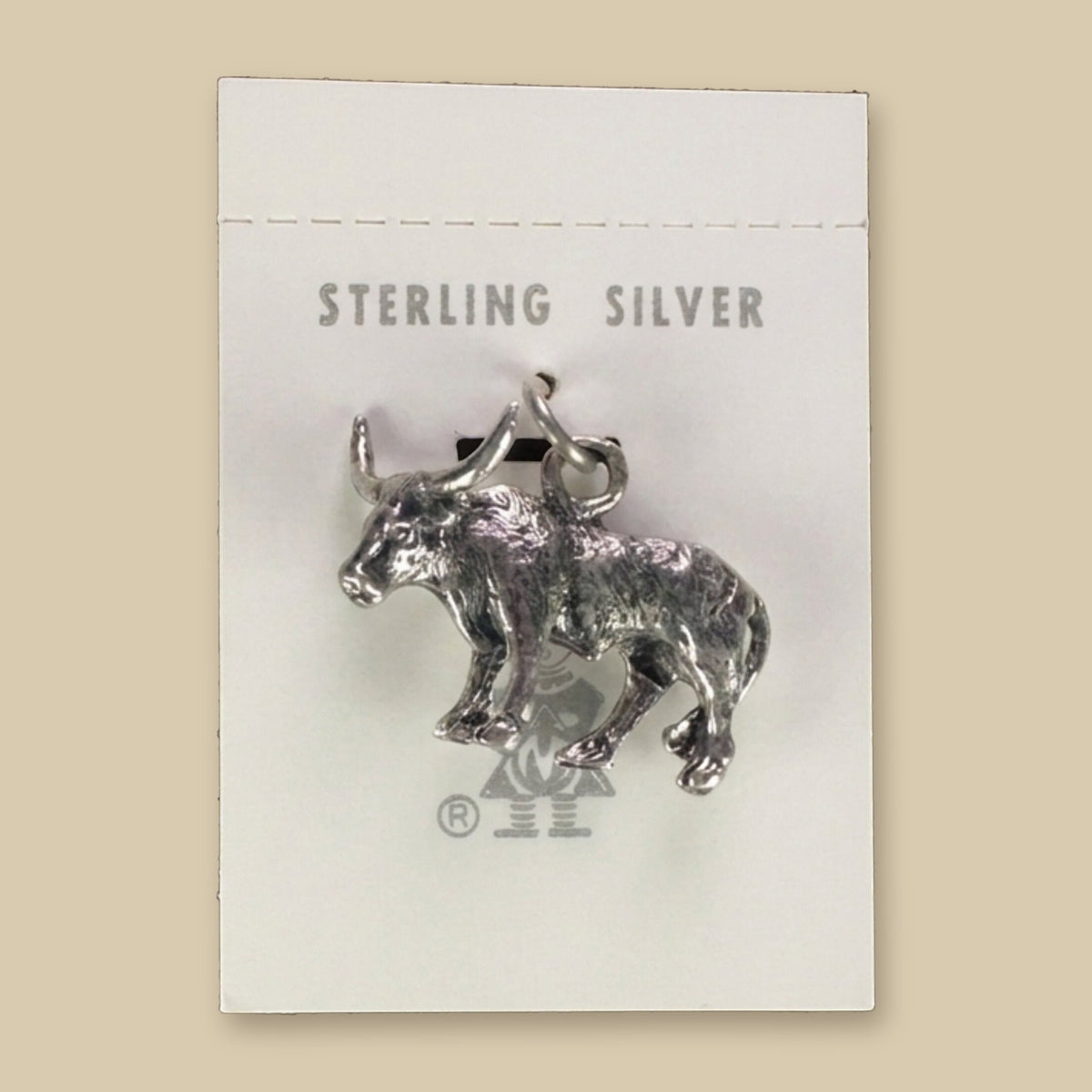 Vintage Maisel's Sterling Silver Longhorn Charm, New Old Stock, shown on a sand background
