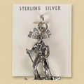 Vintage Maisel's Sterling Silver Skier Charm, New Old Stock, shown on a desert plaster background