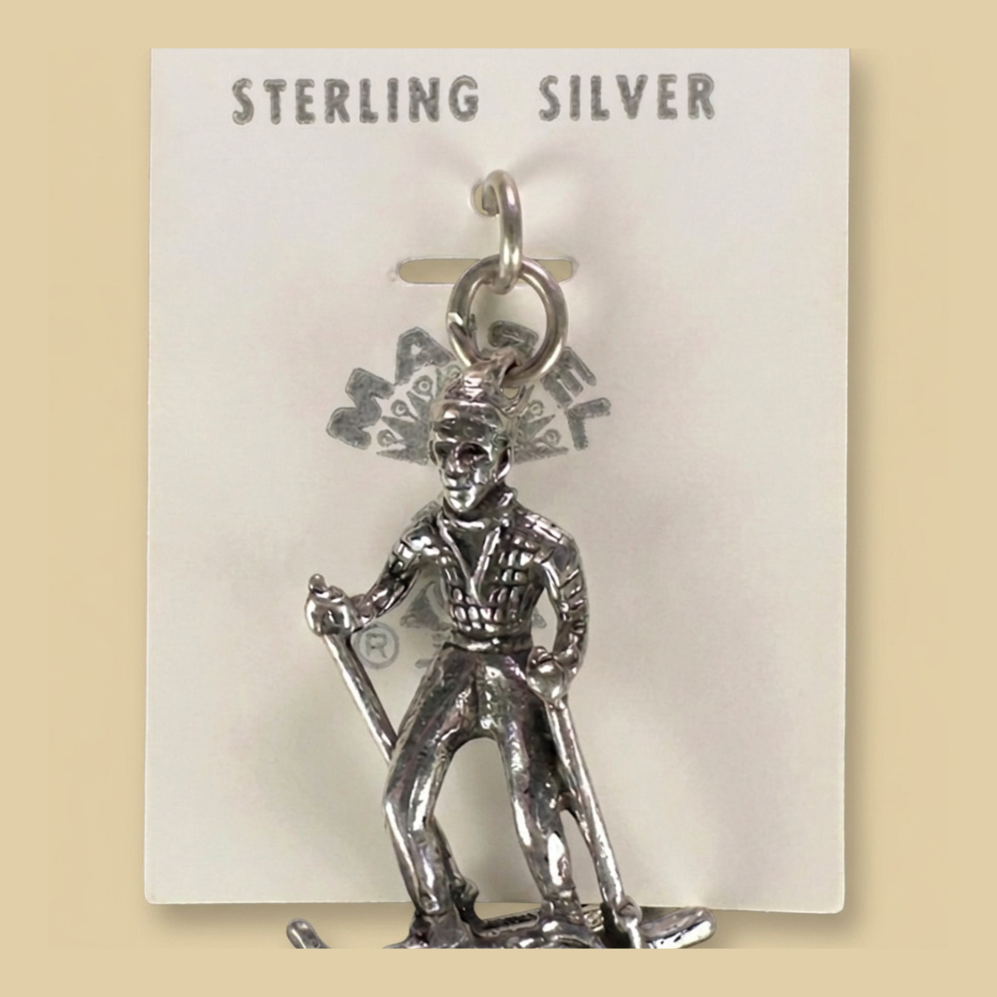 Vintage Maisel's Sterling Silver Skier Charm, New Old Stock, shown on a desert plaster background