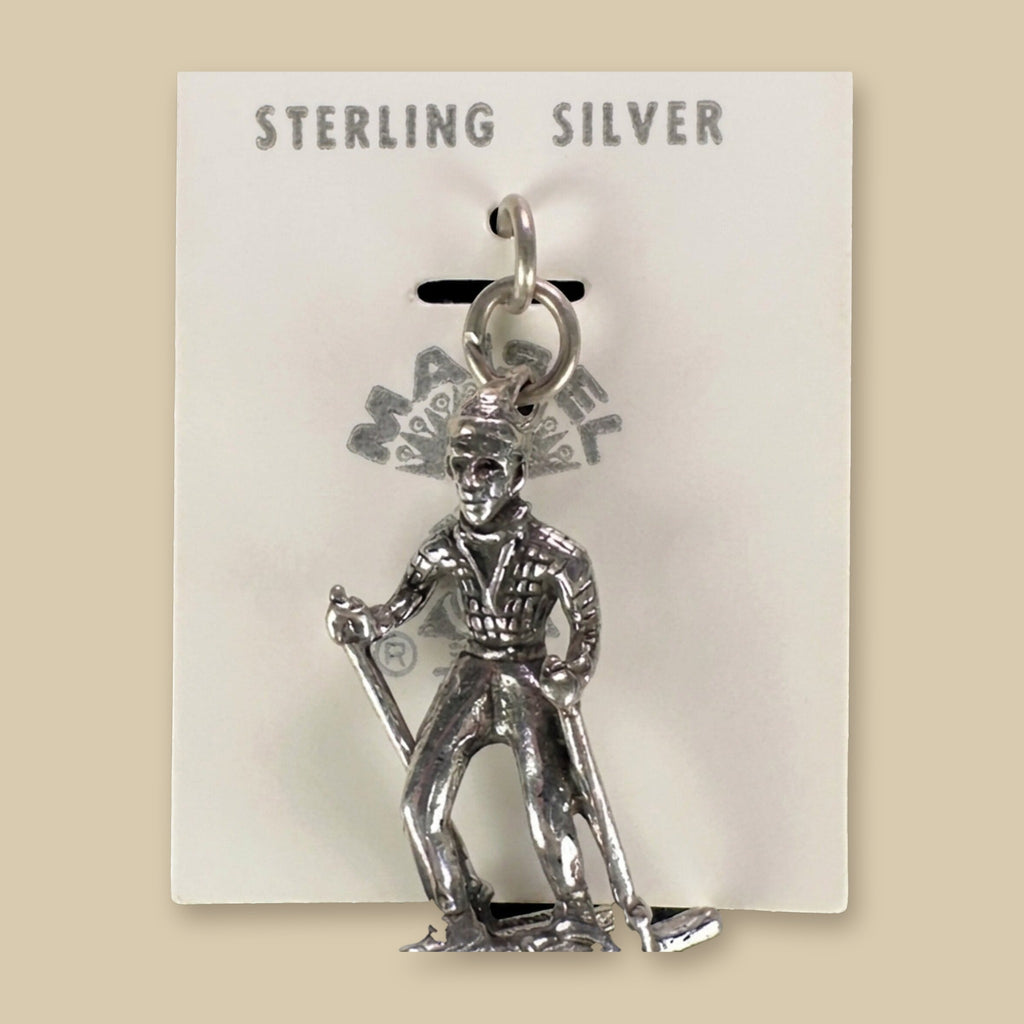 Vintage Maisel's Sterling Silver Skier Charm, New Old Stock, shown on a sand background