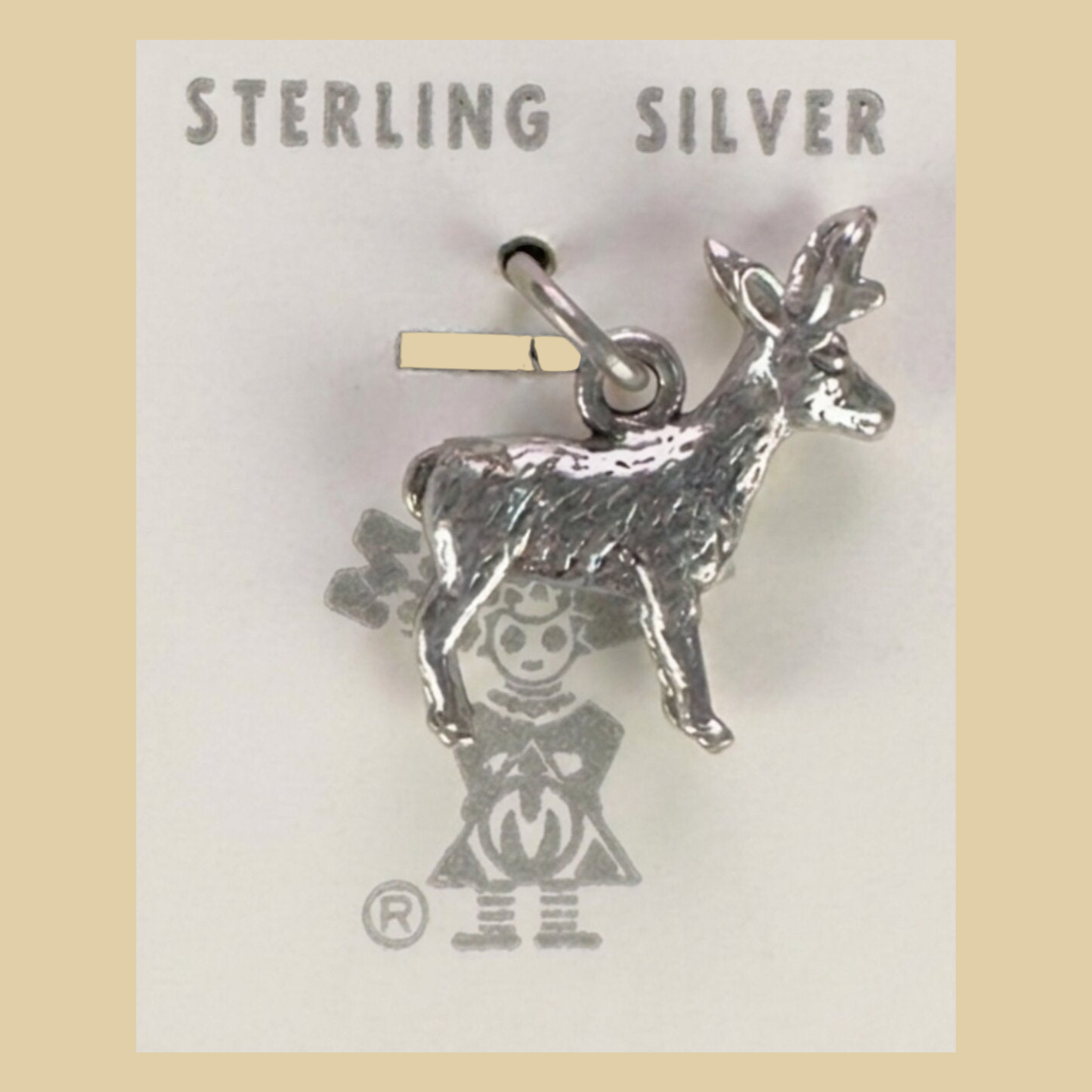 Vintage Maisel's Sterling Silver Standing Elk Charm, New Old Stock, shown on a desert plaster background