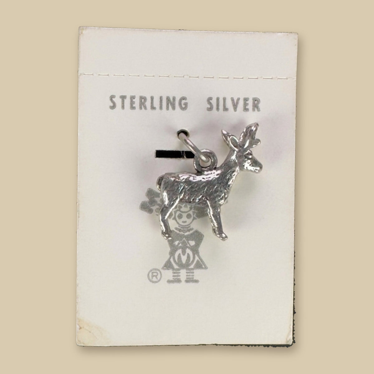 Vintage Maisel's Sterling Silver Standing Elk Charm, New Old Stock, shown on a sand background