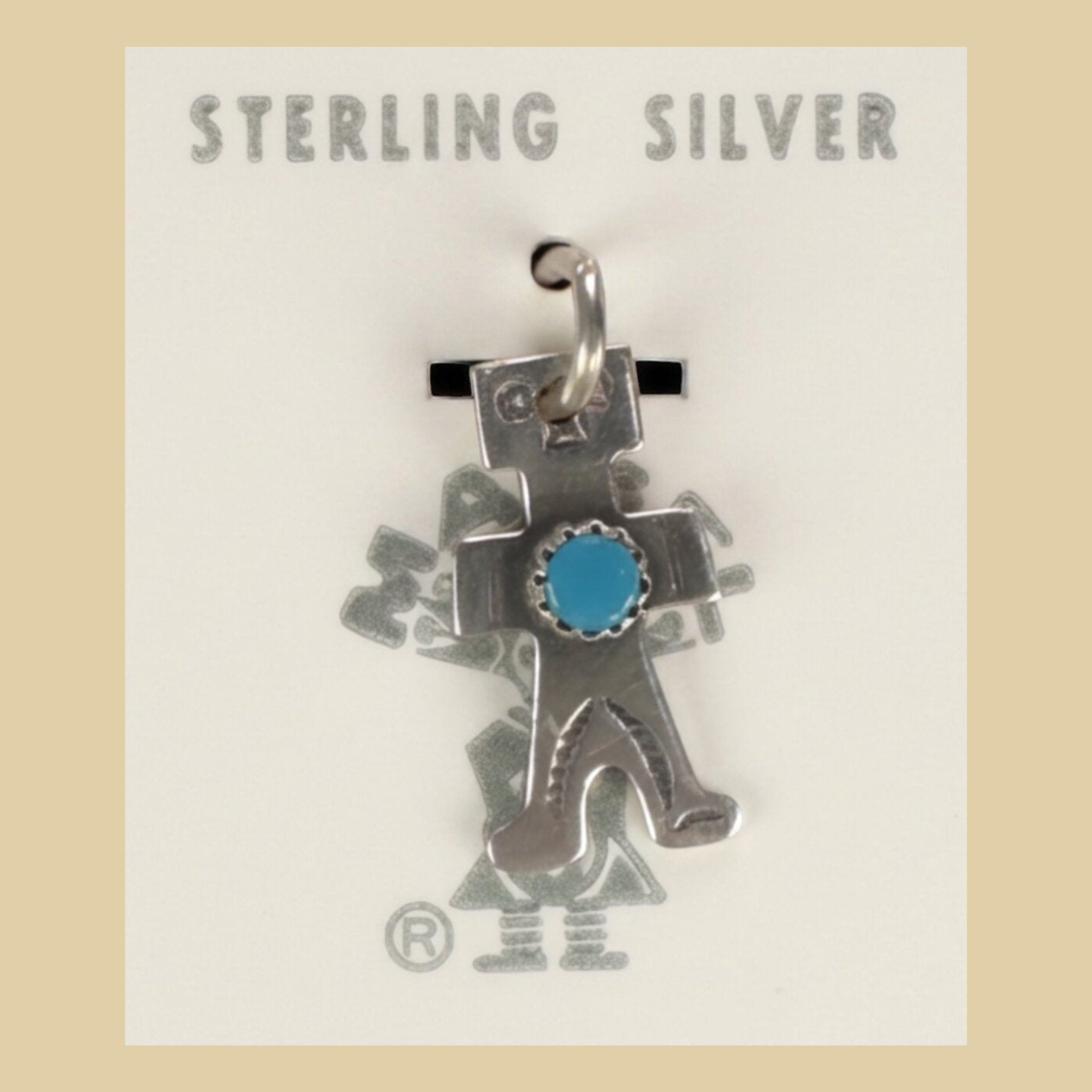 Vintage Maisel's Sterling Silver Turquoise Figure Charm, New Old Stock, shown on a desert plaster background
