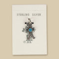 Vintage Maisel's Sterling Silver Turquoise Figure Charm, New Old Stock, shown on a sand background