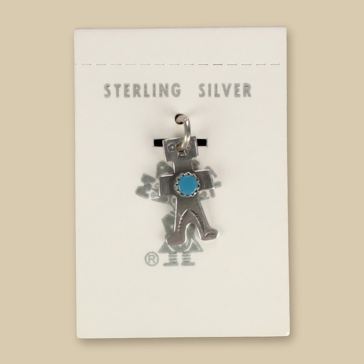 Vintage Maisel's Sterling Silver Turquoise Figure Charm, New Old Stock, shown on a sand background