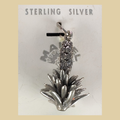 Vintage Maisel's Sterling Silver Yucca Charm, New Old Stock, shown on a desert plaster background