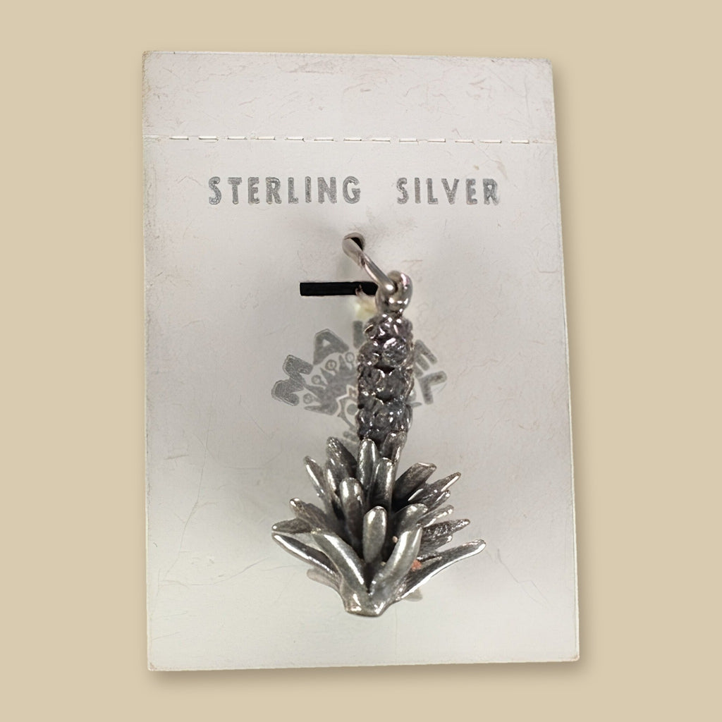 Vintage Maisel's Sterling Silver Yucca Charm, New Old Stock, shown on a sand background