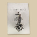 Vintage Maisel's Sterling Silver Yucca Charm, New Old Stock, shown on a sand background