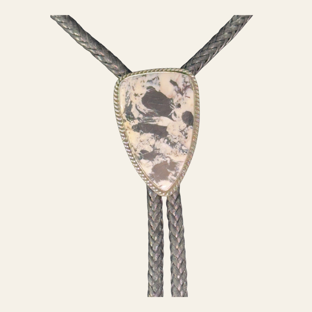 White Buffalo Bolo Tie in Navajo Sterling Silver, by P. Yazzie, shown on a cream background