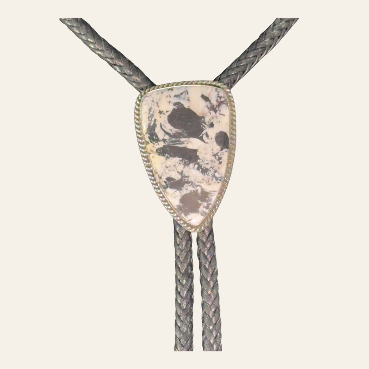 White Buffalo Bolo Tie in Navajo Sterling Silver, by P. Yazzie, shown on a cream background