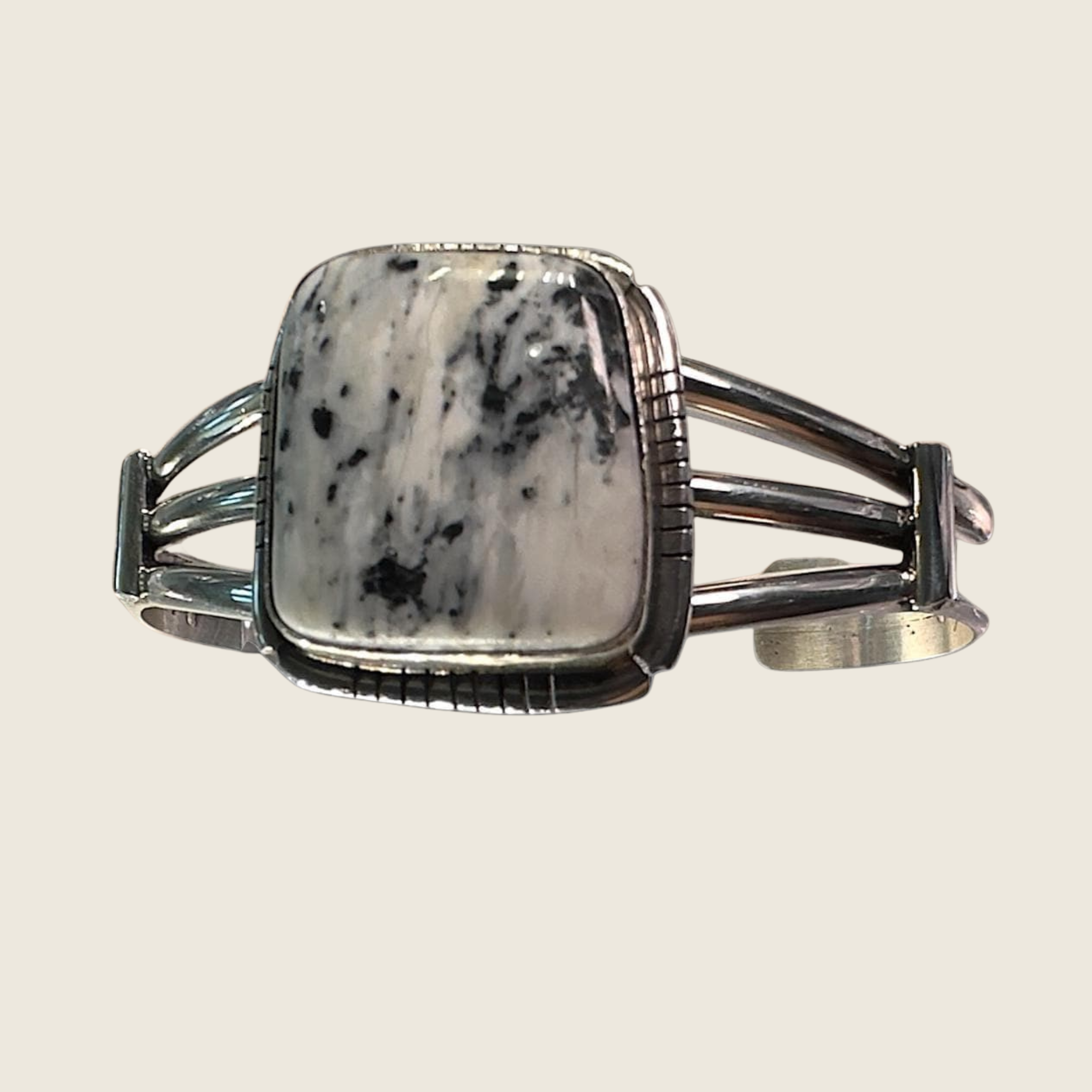White buffalo cuff bracelet in Navajo sterling silver, shown on a bone linen background