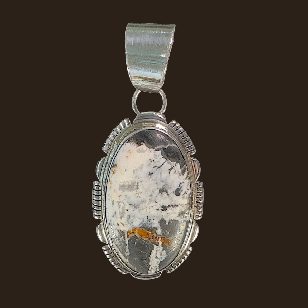 White Buffalo Pendant Necklace in Navajo Sterling Silver, by Leslie Yazzie, shown on an espresso background