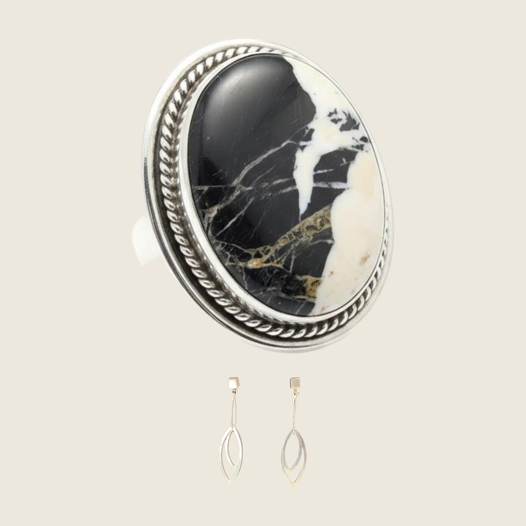White buffalo ring and leaf dangle earrings jewelry set in sterling silver, shown on a bone linen background