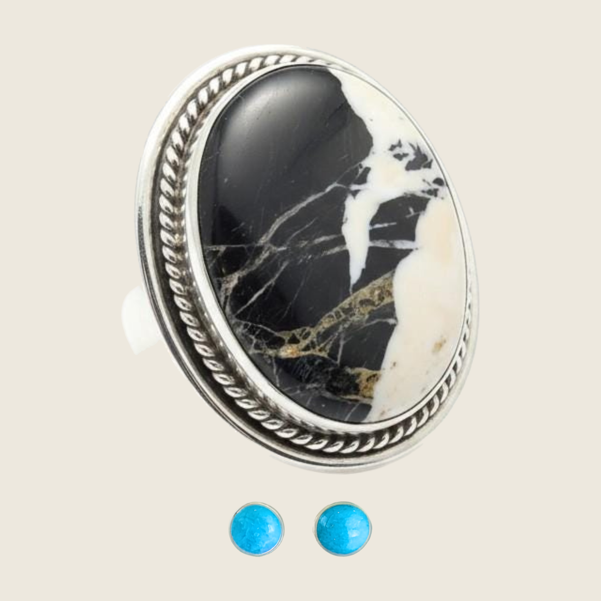 White buffalo ring and turquoise stud earrings jewelry set in sterling silver, shown on a bone linen background
