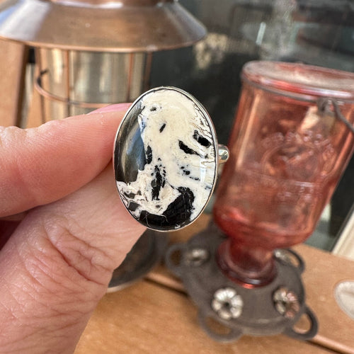 White Buffalo sterling silver ring held in hand, showing the scale of the 12.5 carat oval stone