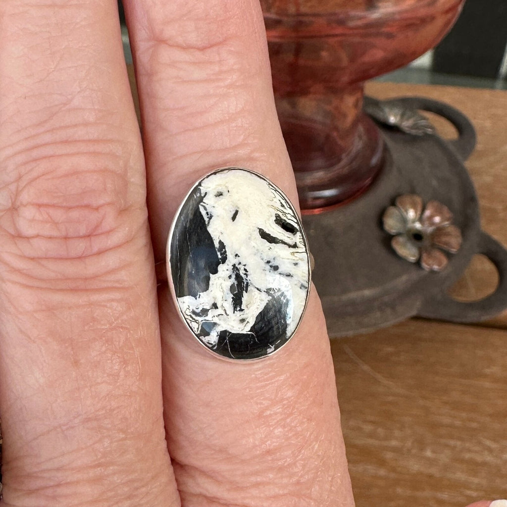 White Buffalo stone ring in sterling silver worn on a finger, size 7 1/2