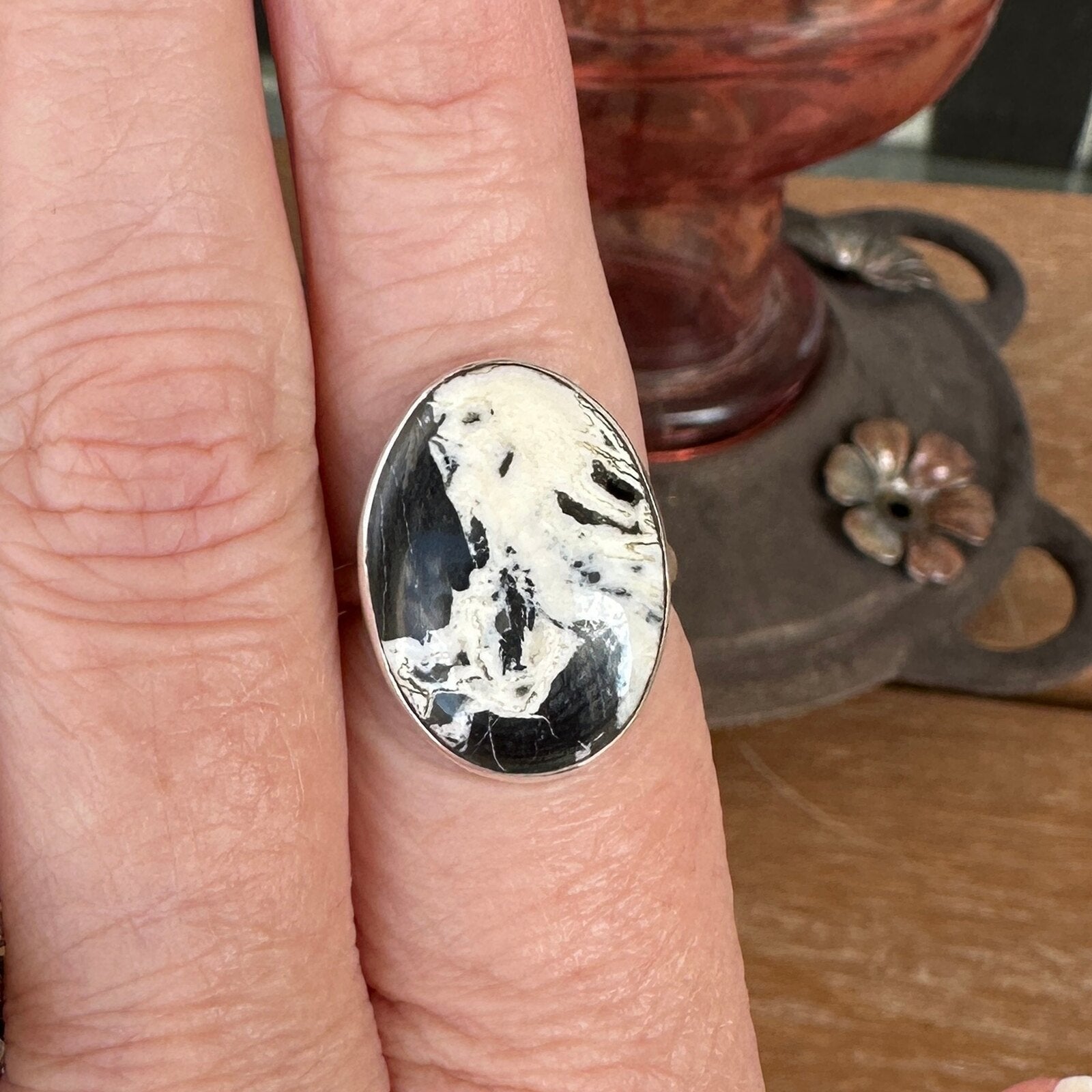 White Buffalo stone ring in sterling silver worn on a finger, size 7 1/2