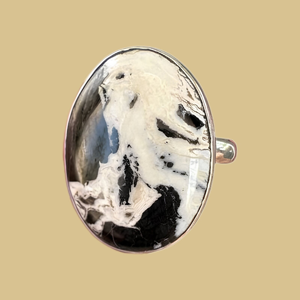 White Buffalo stone ring in sterling silver, close-up of the bright white oval cabochon crossed by black matrix