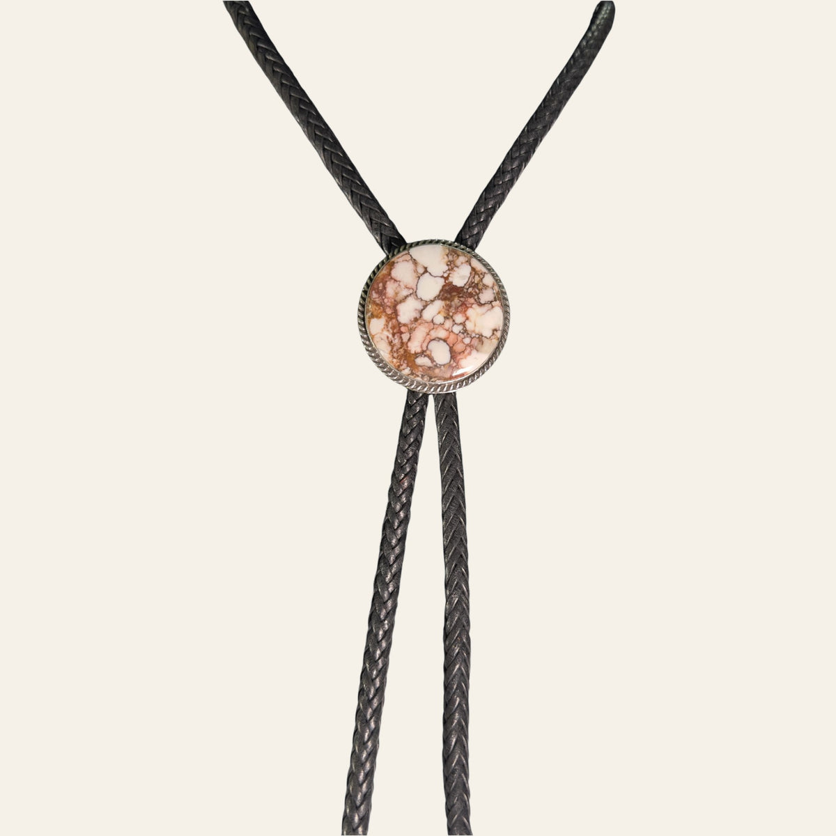 Wild Horse Bolo Tie in Navajo Sterling Silver, by P. Yazzie, shown on a cream background