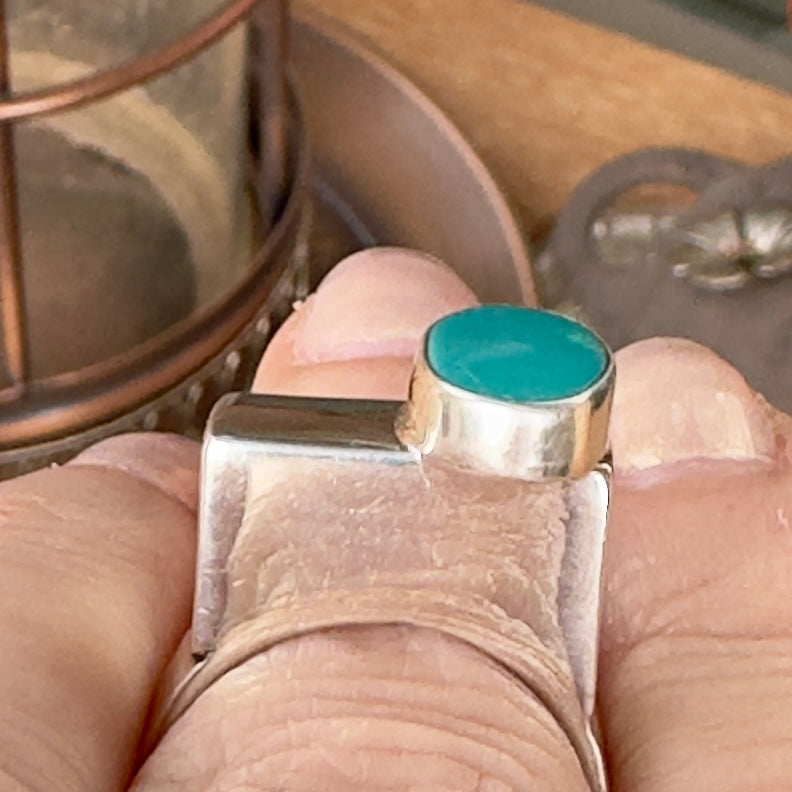 Wildflower Artisans BALAAM sterling silver ring with an off-center oval teal turquoise cabochon on a wide flat band