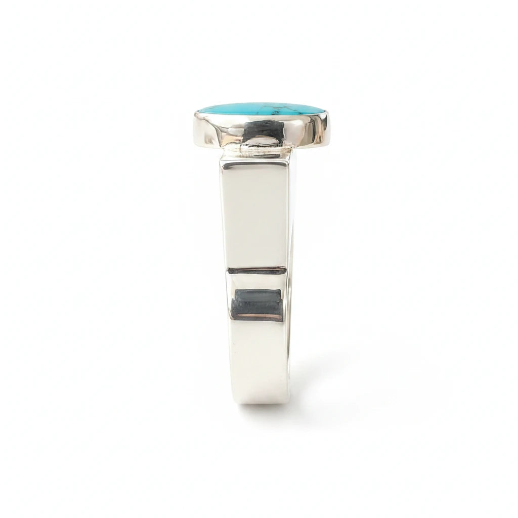 Wildflower Artisans BALAAM sterling silver ring featuring a teal green oval turquoise cabochon on a wide flat band.