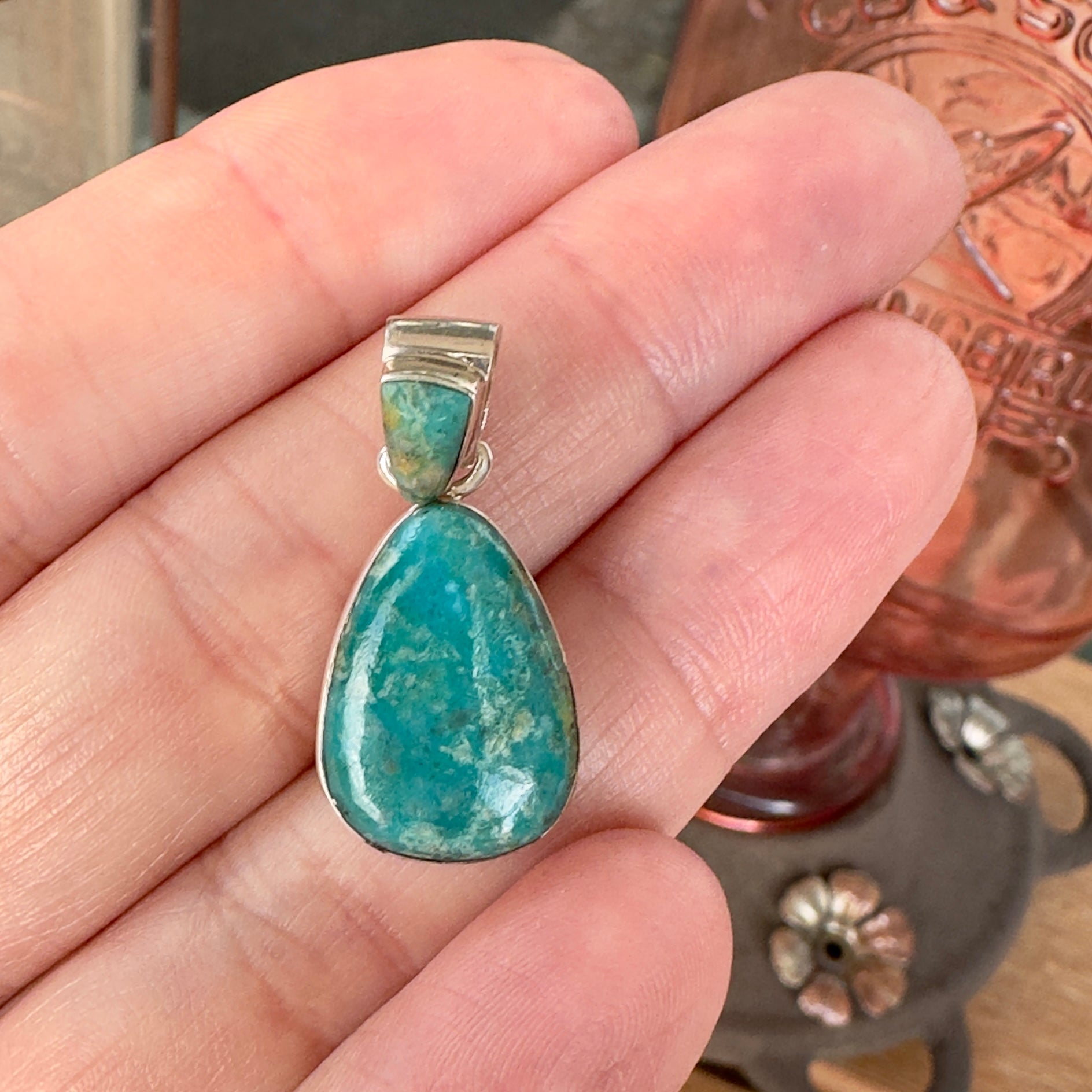 Wildflower Artisans Martinez Fox turquoise teardrop pendant in sterling silver held in a hand