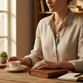 Wildflower Artisans Kingman Red Web turquoise pendant and oval stud earrings set on a woman in a linen shirt