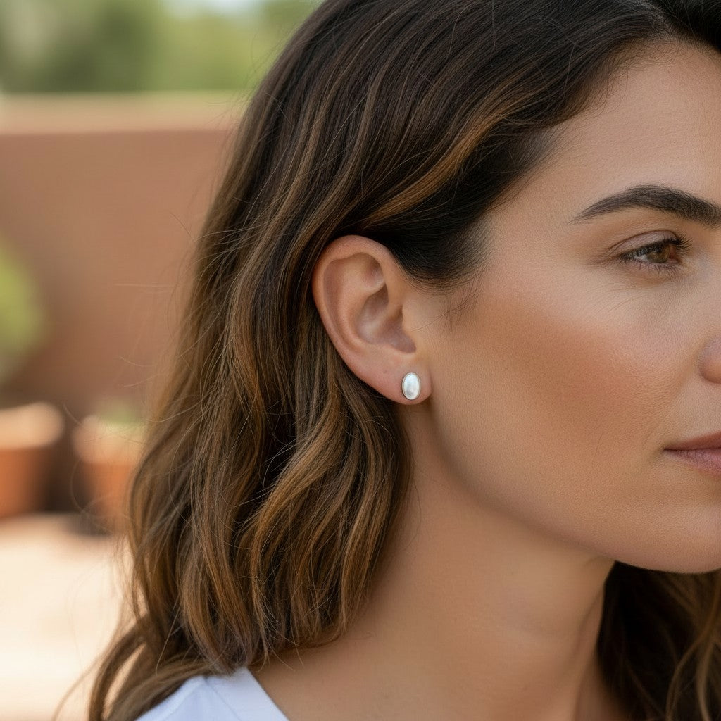Wildflower Artisans oval opal stud earrings in sterling silver worn by a woman with brown hair
