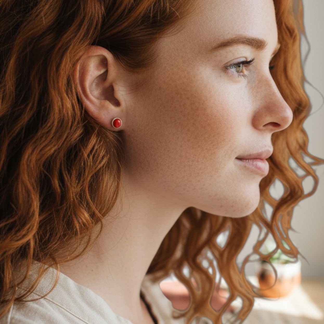 Wildflower Artisans oval spiny oyster stud earrings in sterling silver worn by a woman with red hair