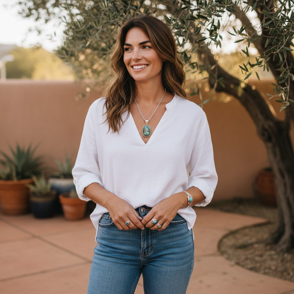 Wildflower Artisans Santa Fe jewelry set featuring a Kingman Red Web turquoise pendant and studs on a smiling model.