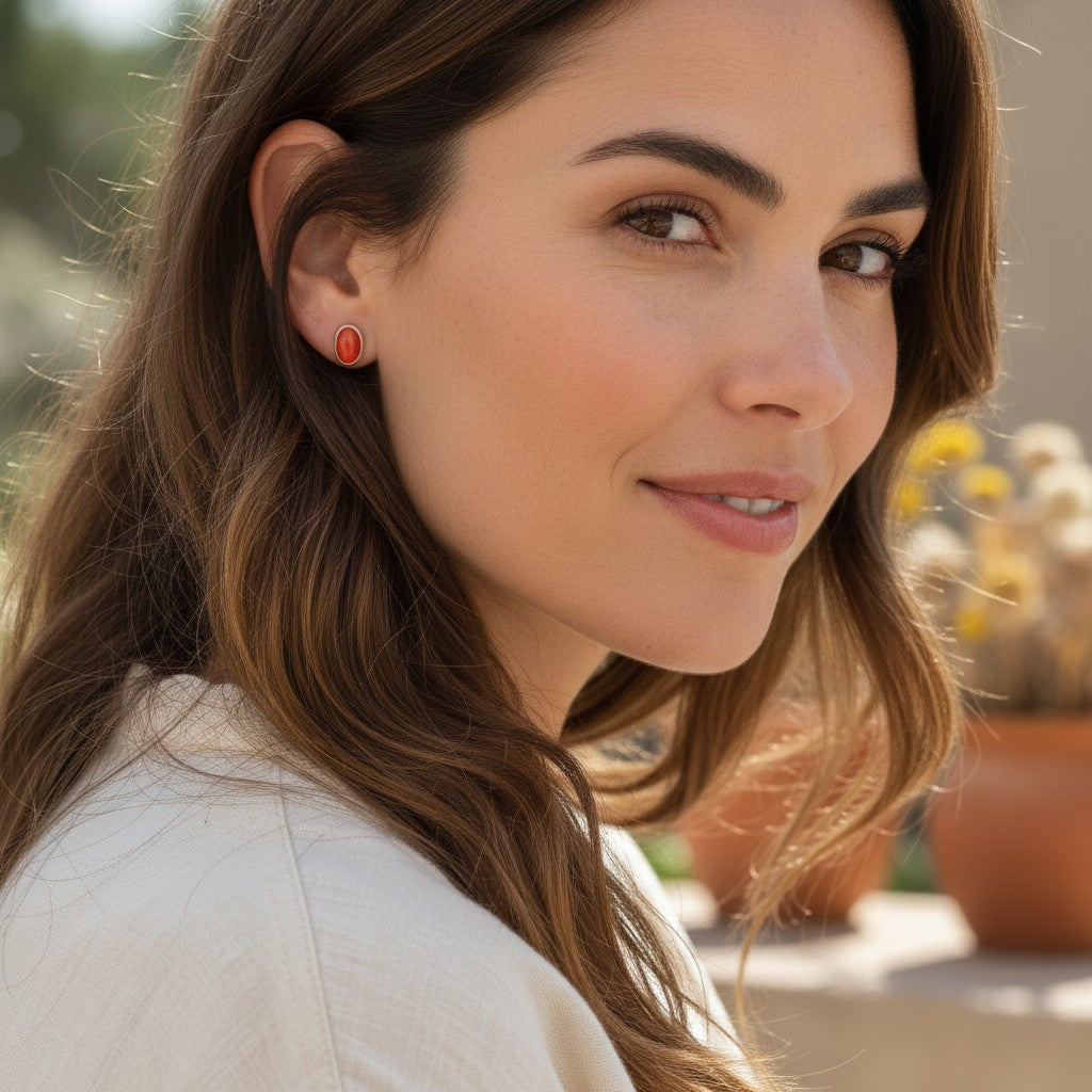 Wildflower Artisans oval spiny oyster stud earrings in sterling silver worn by a woman in a natural outdoor setting.