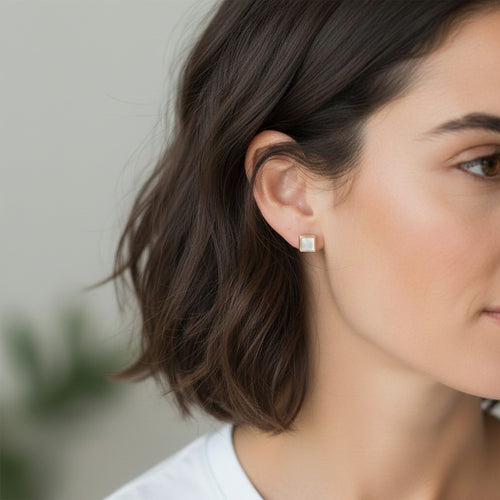 Wildflower Artisans square mother of pearl stud earrings in sterling silver worn on a woman's ear