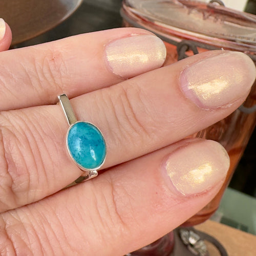 Wildflower Artisans BALAAM square sterling silver ring featuring an oval sky blue turquoise cabochon on a finger.