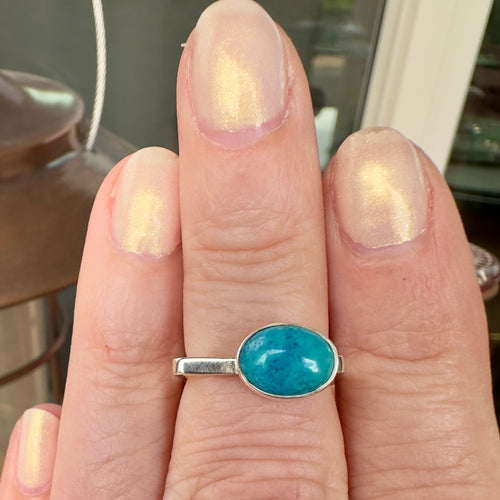 Wildflower Artisans BALAAM square sterling silver band featuring an oval sky blue turquoise cabochon on a finger.