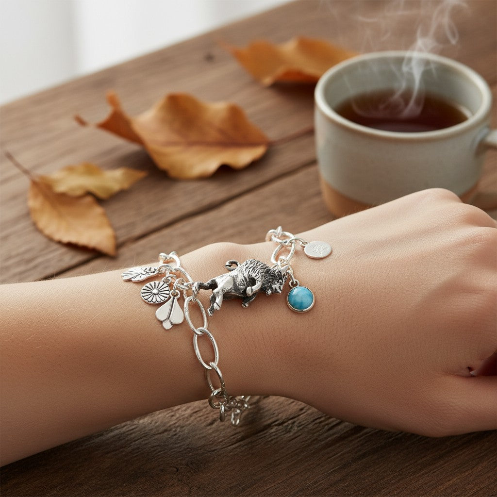 Wildflower Artisans sterling silver buffalo charm on a link bracelet with other charms and a blue stone