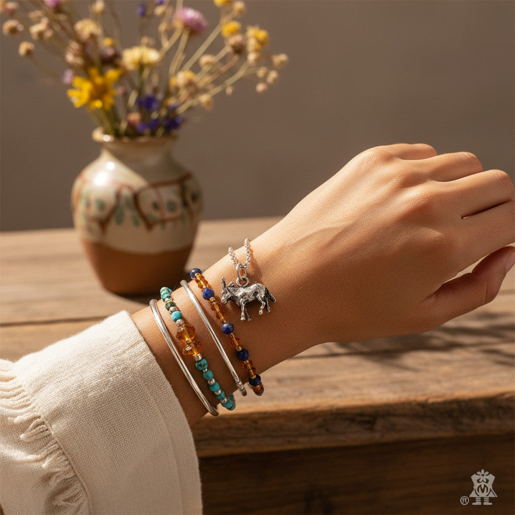 Wildflower Artisans sterling silver burro charm worn on a silver chain bracelet with beaded southwestern style stacks