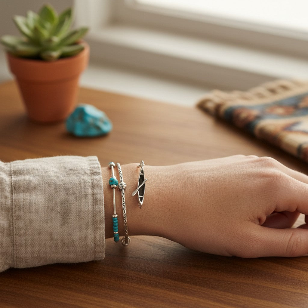 Wildflower Artisans vintage sterling silver canoe charm worn on a bracelet with turquoise and silver beads