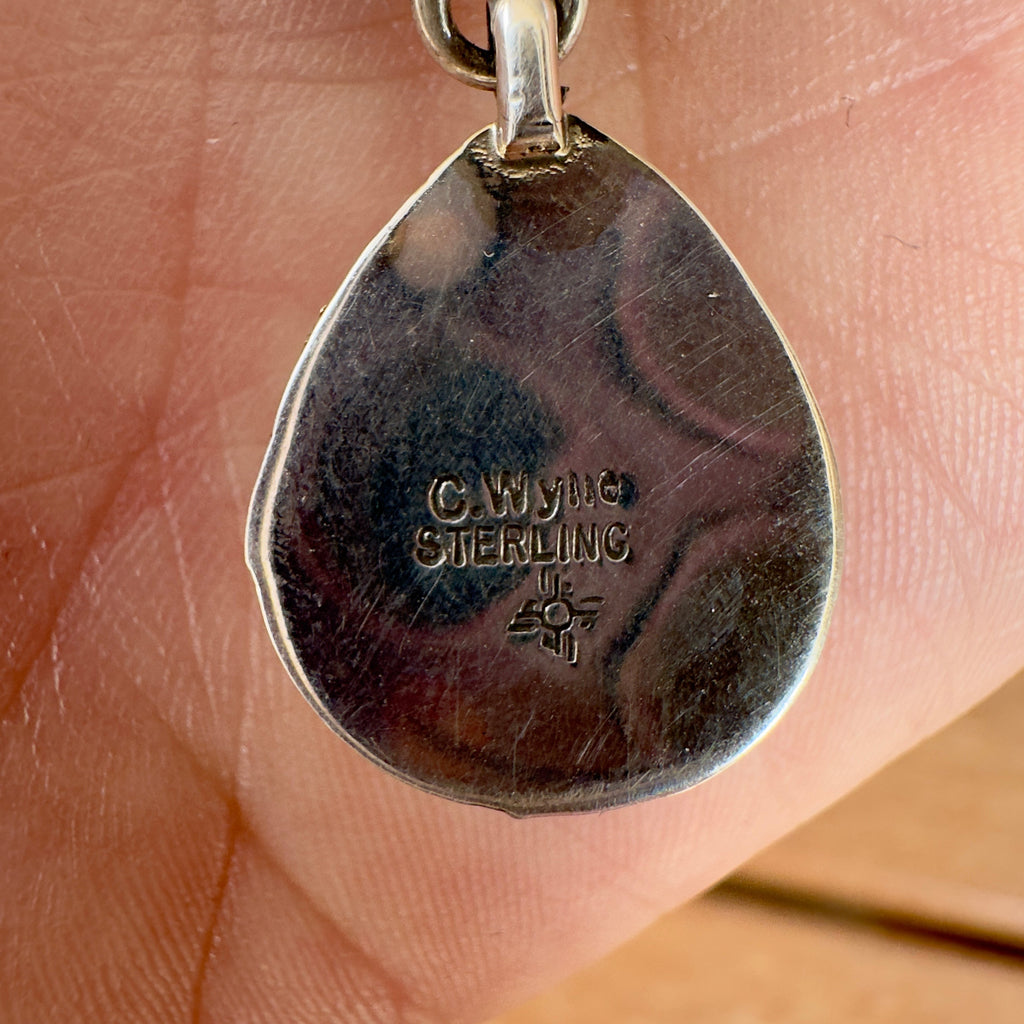 Wildflower Artisans sterling silver pendant back showing C. Wylle hallmark and Zia sun symbol stamp