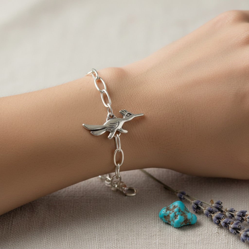 Wildflower Artisans sterling silver roadrunner charm on a delicate chain bracelet worn on a wrist