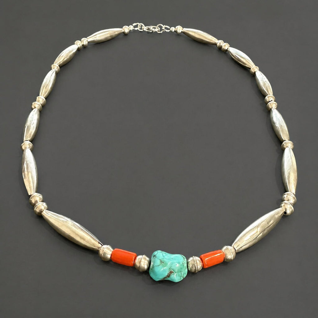 Flat lay of the full necklace showing long tapered sterling beads, saucer spacers and the new sterling clasp