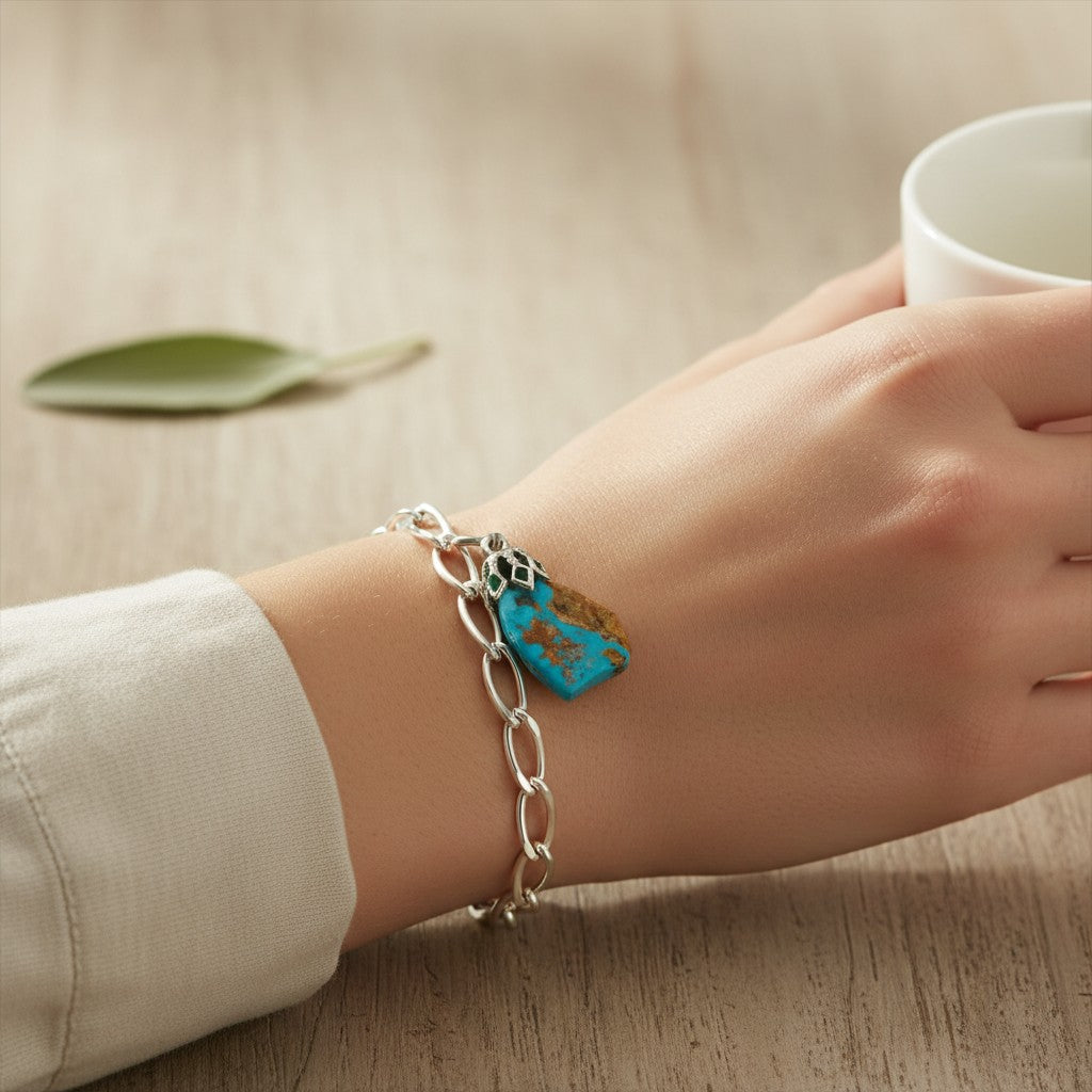 Wildflower Artisans vintage turquoise nugget pendant on a sterling silver chain worn on a wrist