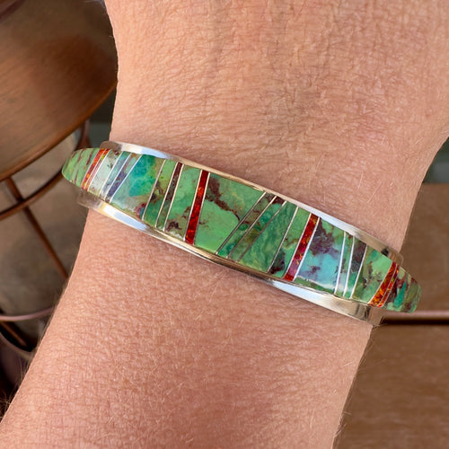 Wildflower Artisans sterling silver cuff featuring Sonoran Mountain turquoise and red opal channel inlay on a wrist.